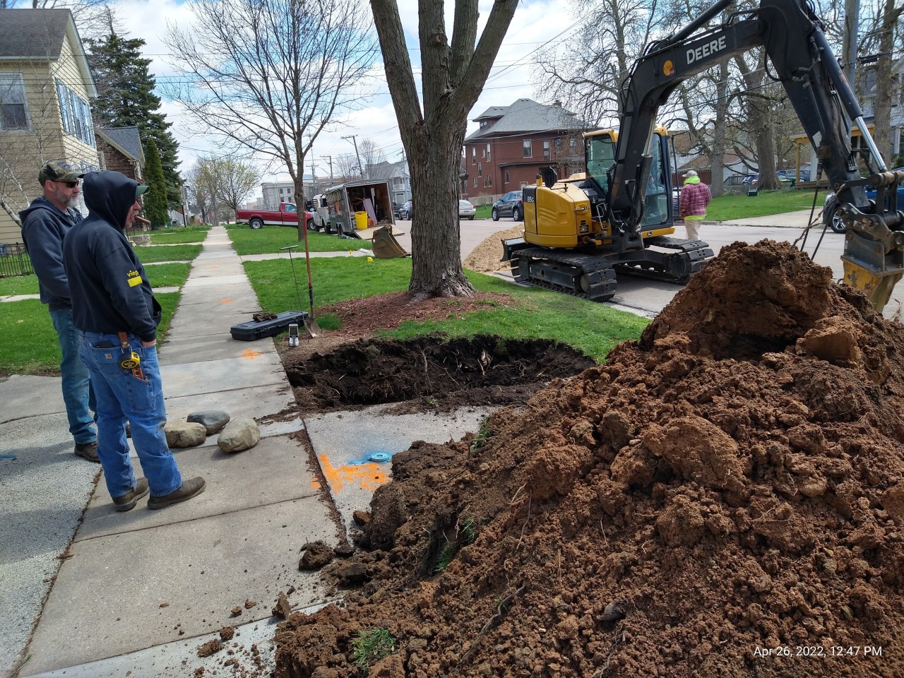 Neighborhood photo of a sidewalk and excavated earth for lead service line replacement